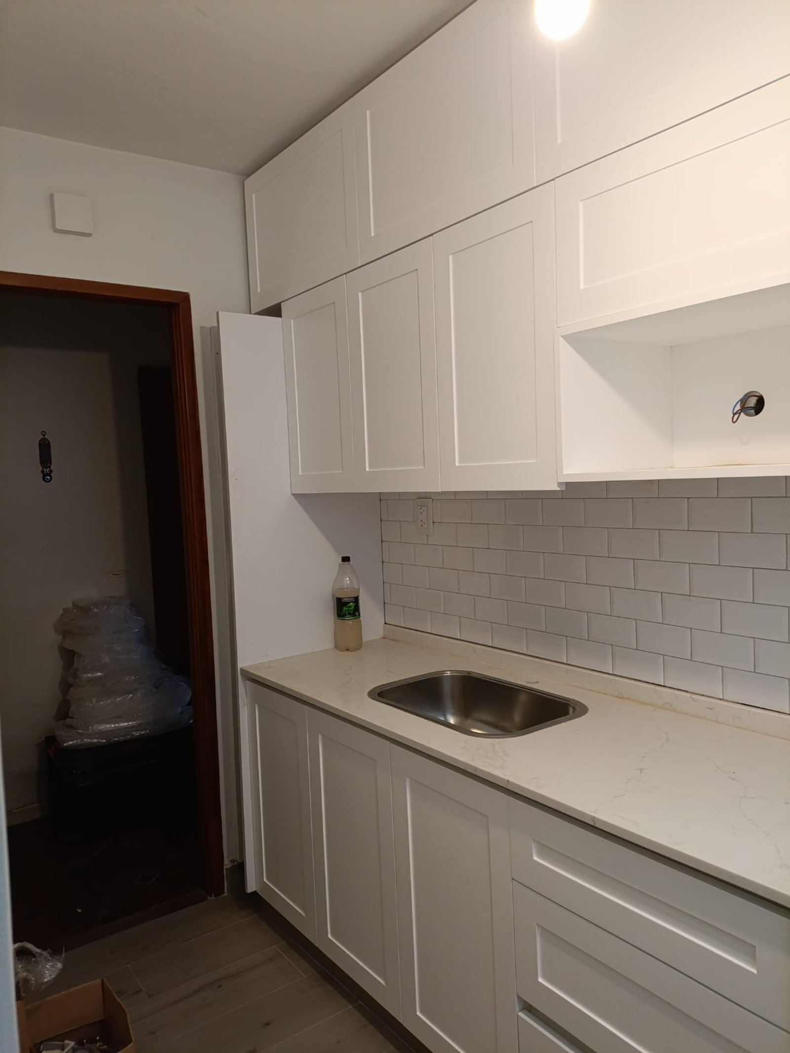 cozinha moderna em construção com armários brancos e bancada de pedra — projeto NEUQUEN, por Licefe Carpentry SRL, em Caballito